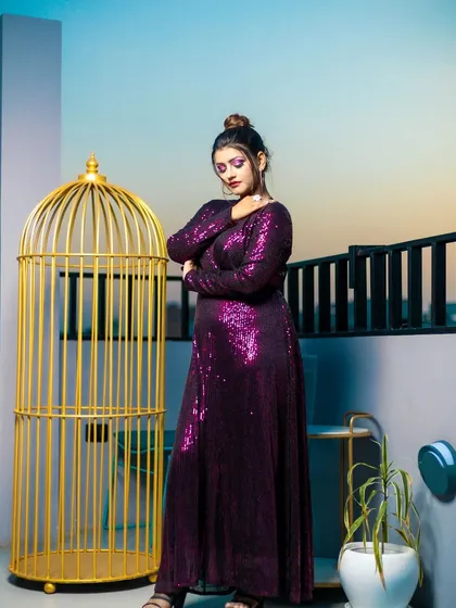 The deep purple eyeshadow and sleek hair create a polished and modern look, perfect for an evening event or commercial shoot.