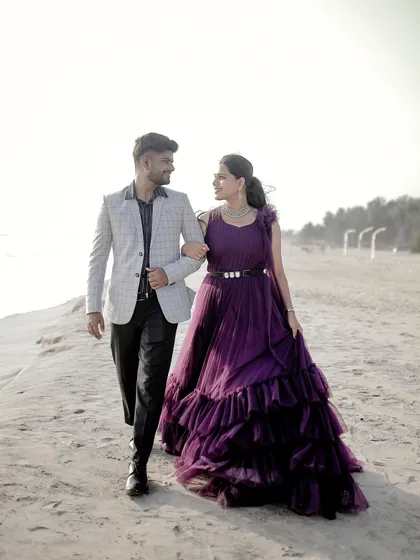 A romantic walk along the shore. The deep purple gown is an elegant and unique color choice for a beach pre-wedding photoshoot.
