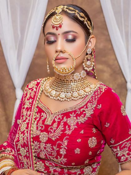 This bride chose a classic red velvet lehenga with silver and gold embroidery from our collection. The pearl-drop Kundan jewellery set she rented adds a touch of timeless elegance.