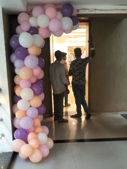 A partial balloon arch in pastel shades of purple, pink, and peach. This type of decor is perfect for framing doorways or creating smaller focal points within a larger event space, adding a touch of color and elegance.