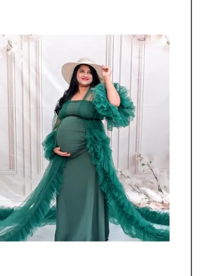A stylish solo portrait featuring our green tulle gown and a chic white hat. This combination creates a fashionable and sophisticated look for a maternity photoshoot.