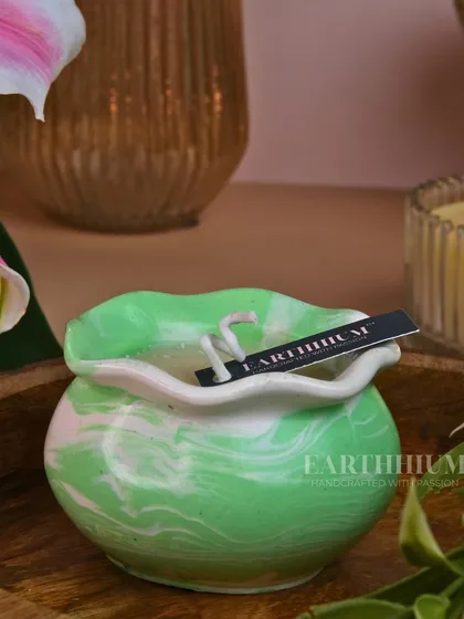 A beautiful marbled green and white Jesmonite candle pot, with a delicate, ruffled edge. Each one has a unique pattern.