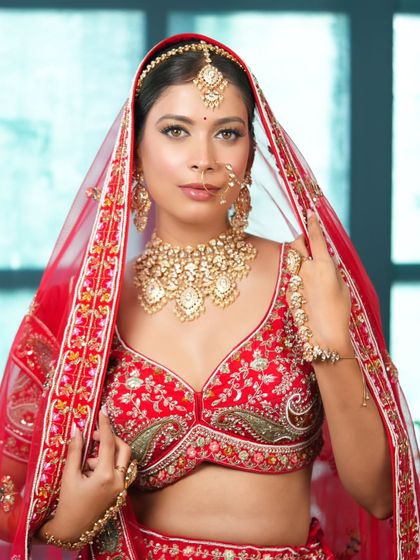 A beautiful bride framed by her red dupatta. My rental service provides the complete ensemble, including the perfectly draped veil for that classic bridal portrait.