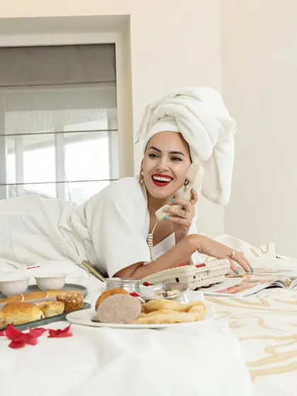 A bright and happy portrait from the hotel bed series. The natural light and the model's smile create a fresh and inviting atmosphere.
