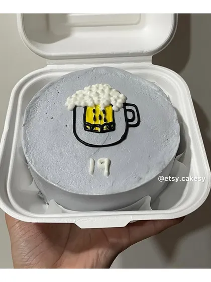A fun bento cake for a 19th birthday, featuring a hand-drawn mug of beer made with frosting.