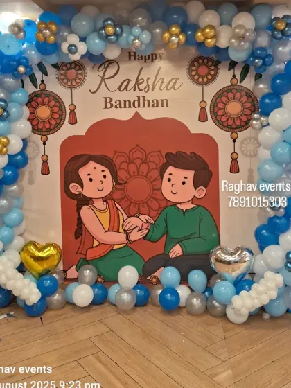 I create custom themed backdrops for any occasion. This setup for Raksha Bandhan includes a large printed banner with festive artwork, framed by a balloon arch in coordinating blue, white, and silver colors, creating a perfect photo opportunity for your event.
