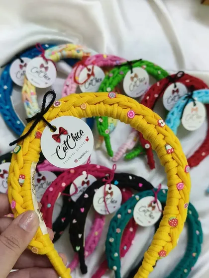 Holding up one of our yellow braided hairbands. You can see the little decorative beads woven in for an extra touch of fun.