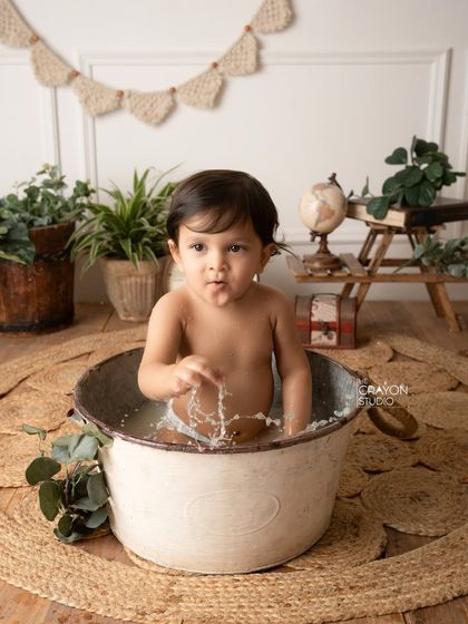 Making a splash. This action shot captures the water flying as the baby plays, his expression a mix of surprise and delight.