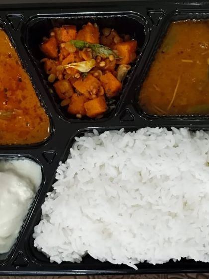 A simple and wholesome vegetarian meal box, perfect for a quick and healthy lunch. It includes rice, two types of curries, and curd.