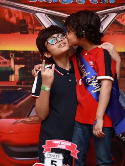 A sweet moment of friendship between the birthday boy and his guest at the Cars-themed party.