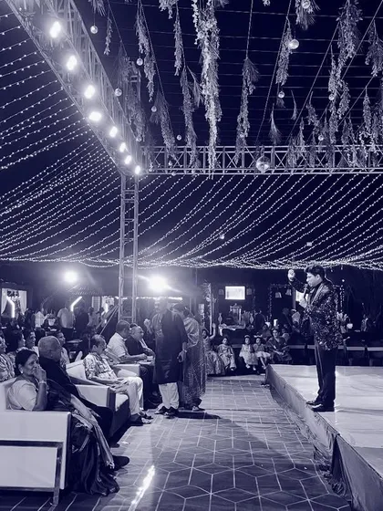 Another perspective of me on a large stage, addressing the audience. The scale of the lighting and setup shows the kind of grand events I am experienced in handling.