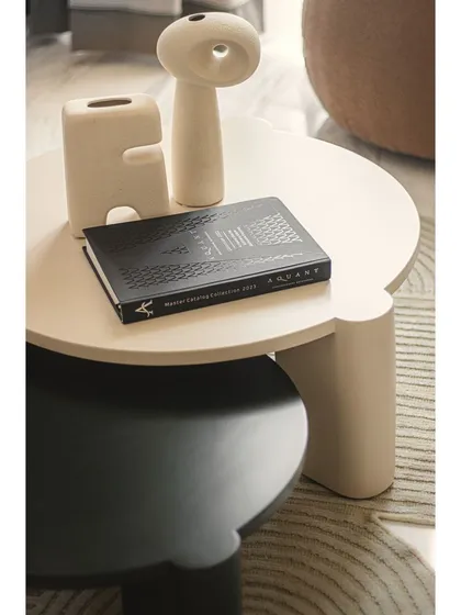 A close-up of the coffee table styling. Simple, sculptural ceramic vases and a design book add a personal touch, reflecting the apartment's blend of luxury and lived-in comfort.