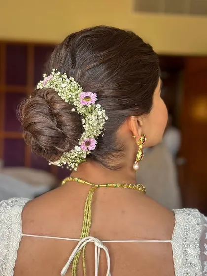 A detailed shot of the floral bun, featuring baby's breath and pink flowers. This shows the intricate work that goes into creating a beautiful floral hair accessory.