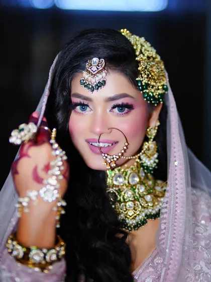 A beautiful Eid look with a focus on purple smokey eyes and glowing skin. The crescent moon henna design adds a perfect festive touch.