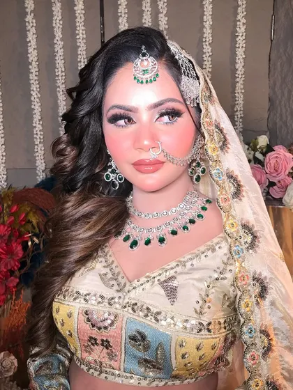 A detailed shot of the makeup for this Pakistani bridal look. The focus is on a radiant complexion, soft pink blush, and beautifully defined eyes and brows.