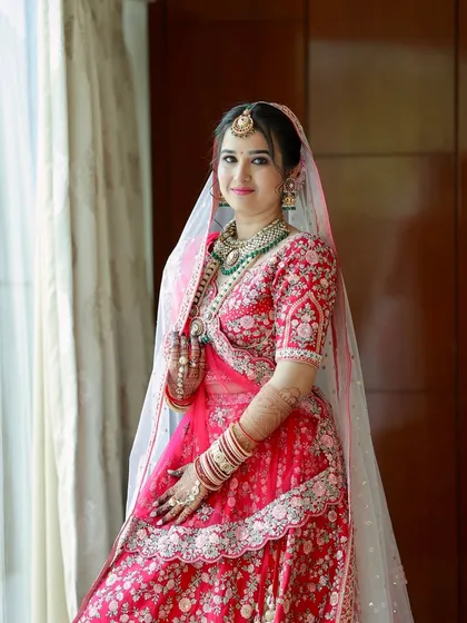 A radiant bride by the window. The natural light enhances her glowing skin and the soft details of her makeup.