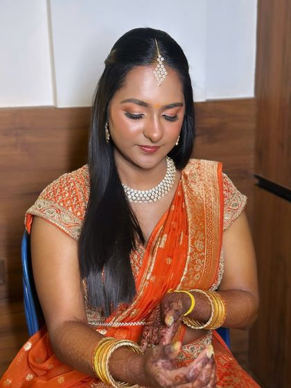 A soft glam look with a traditional touch. The warm, peachy tones on the eyes and cheeks give this bride a beautiful glow for her event.