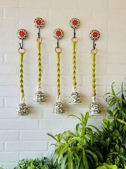 A set of five 'Evergreen' macrame ceramic bells, all in a beautiful green shade. These handcrafted pieces combine the elegance of ceramics with the intricate artistry of macrame, perfect for your garden or balcony.