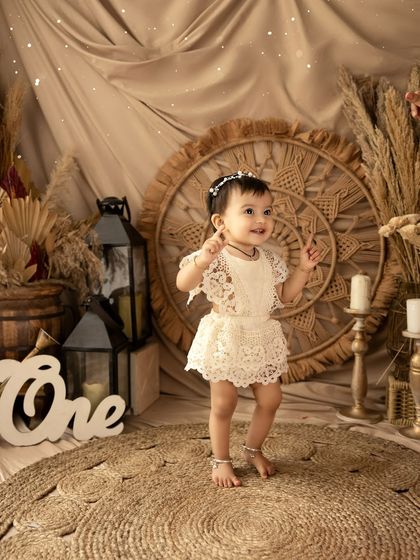 A happy dance from the birthday girl in her boho-chic lace outfit. This theme is perfect for creating timeless and artistic milestone photos.