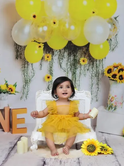 A wide shot of the complete sunflower birthday setup, showing the beautiful arrangement of balloons, flowers, and the "ONE" sign that create a festive atmosphere.