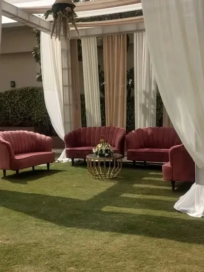 Creating comfortable and elegant lounge areas is crucial for any high-profile event. Here, I've used plush pink velvet sofas and a stylish center table to create an inviting VIP seating area for an outdoor corporate function.