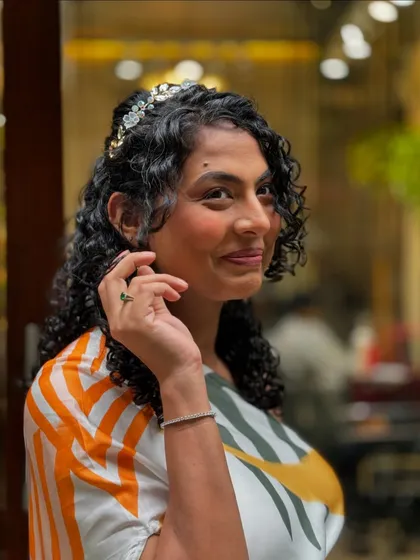 A different angle of her lovely baby shower look. The headband adds a touch of sparkle to her natural curls.