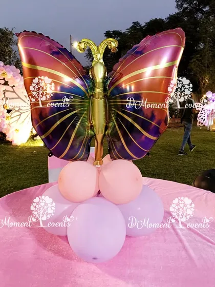 Another beautiful butterfly centerpiece, this one featuring a large, colorful foil balloon on a base of pink and lavender balloons.