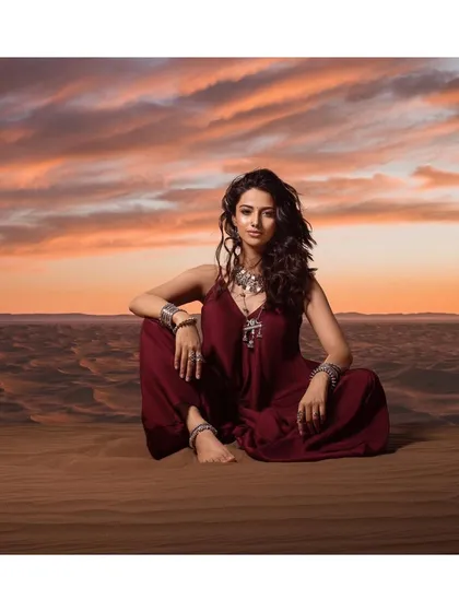 A serene, seated portrait that captures the peaceful yet powerful mood of the desert at dusk. The styling with layered silver accessories completes the narrative.