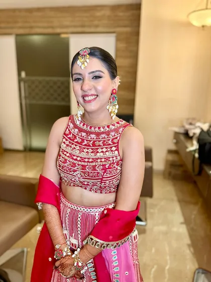 A full view of this beautiful pink and red lehenga, paired with a radiant makeup look and an intricate hairstyle.