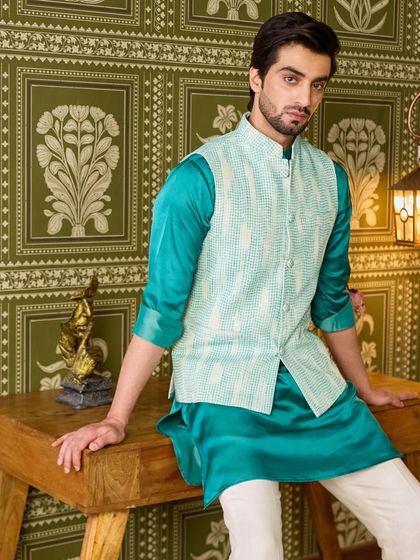 The rich sheen of the silk kurta contrasts beautifully with the matte texture of the jacket. This outfit is perfect for someone who wants to stand out.