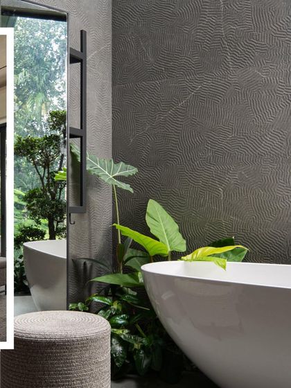 The bathroom in 'Tropis' becomes a spa-like retreat, with a freestanding tub surrounded by indoor plants and a large window looking out to nature.