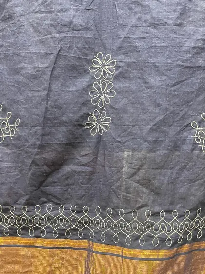 The border and butis of the Sashiko-embroidered saree. The combination of linear and floral patterns creates a balanced and harmonious design.