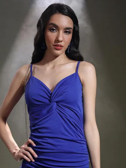 A close-up on the details. The twist-front neckline of the dress is the focus here, with soft glam makeup and simple hair completing this elegant evening look.