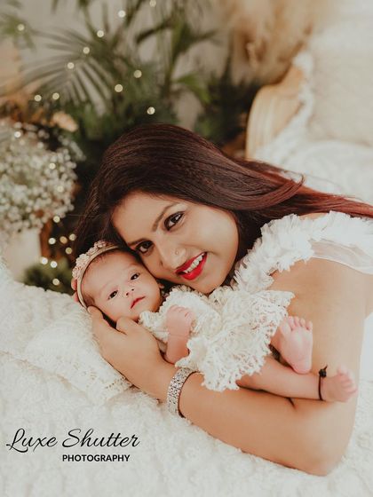 A sweet mother-daughter moment from a newborn session. The delicate lace outfits and soft lighting create a dreamy and angelic feel.