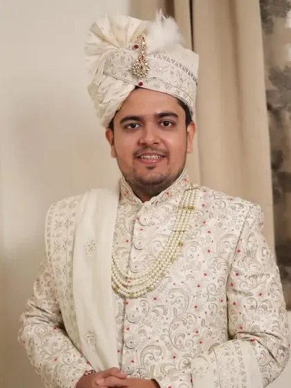 A three-quarter shot of the groom in his wedding attire. The overall look is cohesive, from the well-styled hair to the elegant sherwani.