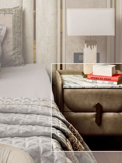 A close-up of a bespoke bedside table with a marble top and plush, upholstered drawers. The unique handle and curved form make it a stylish companion for any bed.