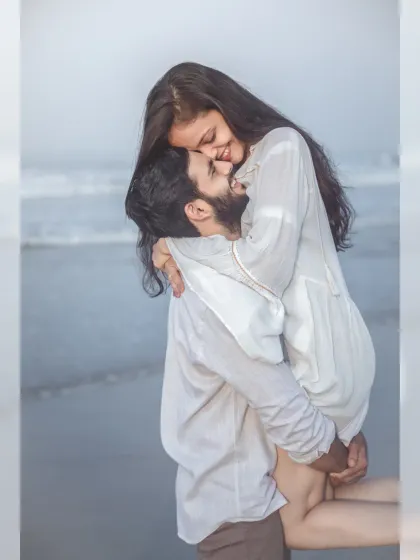 A joyful and romantic lift on the beach, capturing a moment of pure happiness and affection between the couple.