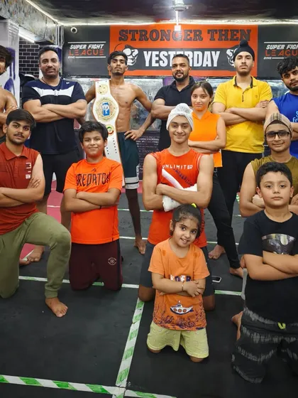Our attitude is in our blood. The team, including one of our champions with his belt, posing with confidence.