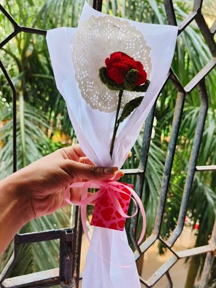 A single red rose, wrapped beautifully with a paper doily. This shows how even one flower can be a stunning and thoughtful present.
