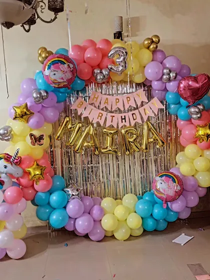 Another angle of the unicorn ring decoration, showing the full circle of balloons in yellow, pink, purple, and blue.