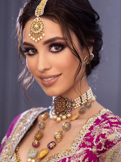 A smiling portrait of the purple smokey eye look, showing that even dramatic makeup can look joyful and radiant.