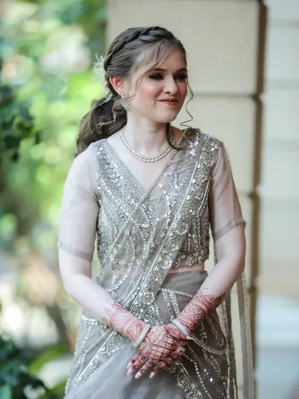 This client, dressed in an elegant silver-grey saree, needed a look that was both soft and defined. I created a subtle smokey eye and a classic hairstyle.