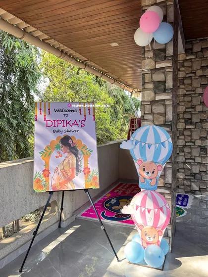Make your guests feel welcome from the moment they arrive with a personalized welcome stand. This one, for Dipika's baby shower, features custom artwork and is paired with cute hot-air balloon decorations.