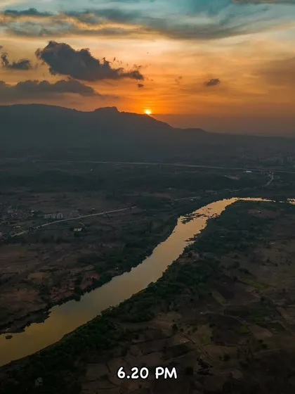 The sun setting behind the mountains at 6:20 PM, with the river reflecting the warm colors of the sky.