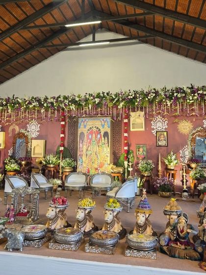 A detailed view of the offering table at the naming ceremony, with a focus on the silver cow statues and traditional dolls.