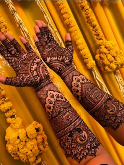 This design features beautiful peacock and house motifs against a backdrop of marigold flowers, capturing the festive spirit of a mehndi ceremony.