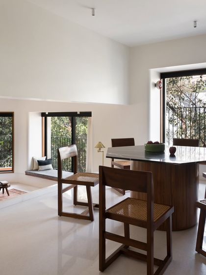 A hexagonal dining table I designed to create a unique focal point in this multi-level space. The solid, sculptural base is made of wood, while the top is a polished, dark stone, offering a durable and elegant surface.