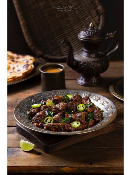 Mutton Fry with Irani Chai, a breakfast special at The Nawaab's. The composition captures a unique meal pairing, showcasing the restaurant's diverse offerings.