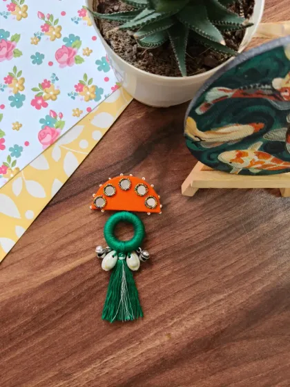 A selection of my Navratri-themed hair brooches and pins. These feature colorful fabric, mirrors, cowrie shells, and even a small bird charm, perfect for adorning a festive bun.