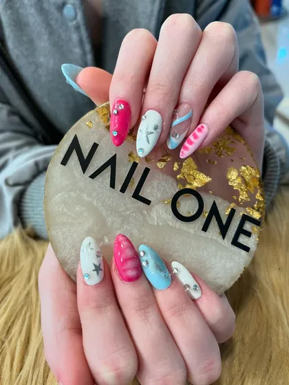 This playful set is all about mixing and matching. We combined bright pink, blue, and white nails with various embellishments, including silver stars, rhinestones, and hand-drawn art for a fun and eclectic look.